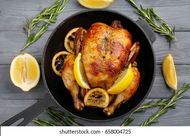 Homemade baked chicken with lemon on wooden background - Shutterstock ID 658004725