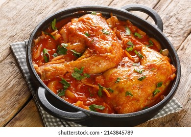 Homemade baked chicken with spicy onion tomato sauce close-up in a frying pan on the table. horizontal - Shutterstock ID 2143845789