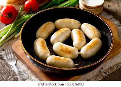 Homemade baked grilled meat chicken sausage in a cast iron pan on a rustic background. - Powered by Shutterstock