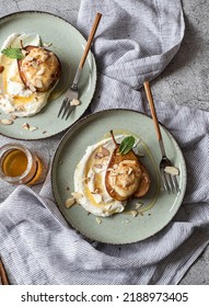 Homemade Baked pear halves stuffed with ricotta, honey, cinnamon and vanilla and served in whipped ricotta cream with almond petals, honey and fresh mint leaves. Top view - Shutterstock ID 2188973405