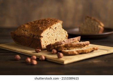 Homemade Banana Bread With Hazelnuts On A Cutting Board On A Rustic Wooden Background. Vegan Pastries. Healthy Breakfast. Selective Focus.