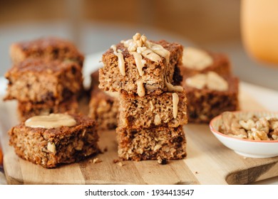 Homemade banana bread loaf with walnuts sliced on wooden cutting board overflowed with peanut butter. Close Up view, horizontal - Powered by Shutterstock