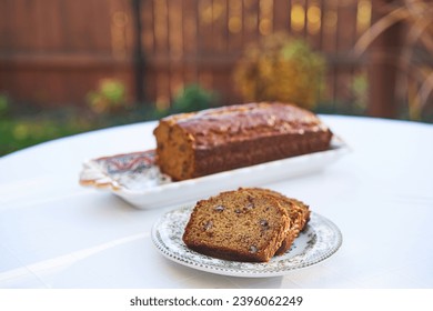 Homemade banana bread with pecan nuts served as a delicious and tasty breakfast or snack outside in the garden during summer sunny morning. Ideal dish for modern healthy, lowcarb and balanced diet.