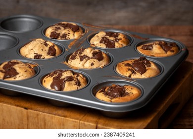 Homemade banana and chocolate muffins from the oven in a baking tray with melting chocolate. - Powered by Shutterstock