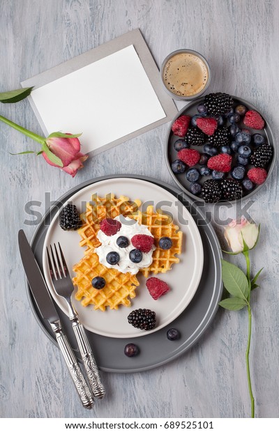 Homemade belgian waffles, gray ceramic cup of\
coffee and berries with copy\
space