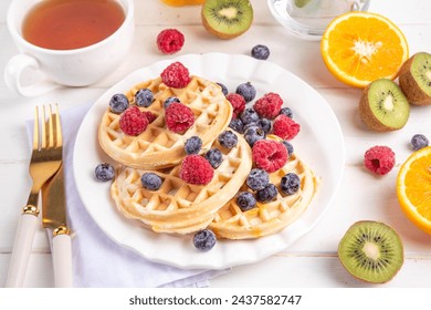 Homemade belgian waffles with summer berries and honey on white wooden table, Delicious brunch or breakfast belgian waffles - Powered by Shutterstock