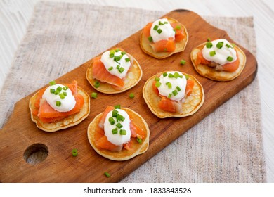 Homemade Blini With Smoked Salmon, Creme And Chives On A Rustic Wooden Board, Side View.