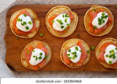 Homemade Blini With Smoked Salmon, Creme And Chives On A Rustic Wooden Board, Top View. Flat Lay, Overhead, From Above.