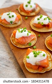 Homemade Blini With Smoked Salmon, Creme And Chives On A Rustic Wooden Board, Low Angle View. 