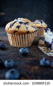 homemade blueberry muffins on dark wood surface