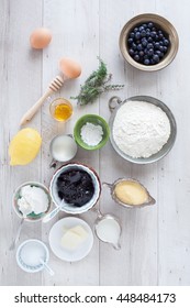 Homemade Blueberry Pancakes Ingredients: Blueberries, Flour, Cornmeal, Lemon, Honey, Thyme, Butter, Eggs, Blueberries Jam, Sugar, Milk, Buttermilk, Baking Powder. Flat Lay.