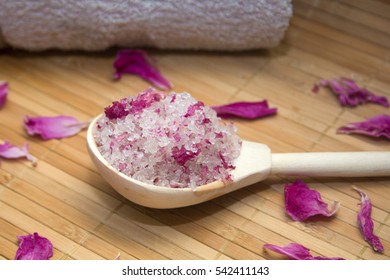 homemade body scrub from sea salt and rose petals and peony pink towel on a straw Mat. Spa concept