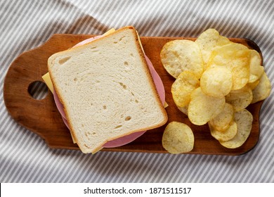 Homemade Bologna And Cheese Sandwich On A Rustic Wooden Board On Cloth, Overhead View. Flat Lay, Top View, From Above.