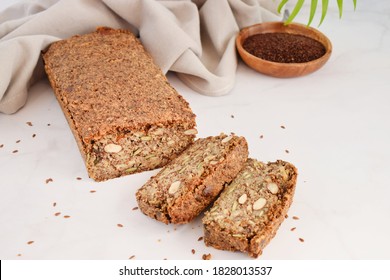 Homemade bread with hazelnut and flax seeds on a wooden Board on light grey marble background close-up. Food for diet and health. Healthy almond bread, Keto, ketogenic diet, paleo, low carb fat