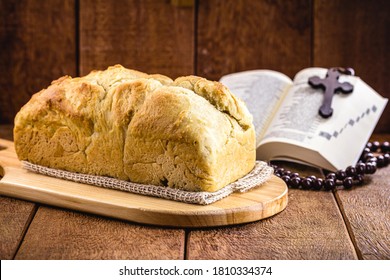 Homemade Bread Made In The Easter And Eucharist Period, Called Christ Bread, Religious Symbol, With Bible And Crucifix In The Background