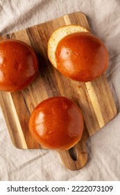 Homemade Brioche Hamburger Buns On A Wooden Board, Top View. Flat Lay, Overhead, From Above. 