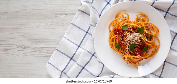 Homemade Bucatini All Amatriciana Pasta In A Plate On A White Wooden Surface, Top View. Flat Lay, Overhead. Copy Space.