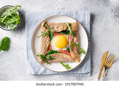 homemade buckwheat crepe galette with egg, ham and spinach on gray background. Traditional French dish. top view - Shutterstock ID 1917007940