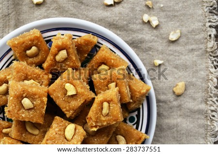 Homemade burfi - traditional indian sweets made of milk, chickpea flour, coconut flakes, cardamom and cashew nut