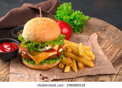 Homemade burger with beef, cheese and vegetables on a brown background. Fast food. Horizontal view, space for copying. - Shutterstock ID 1984083518