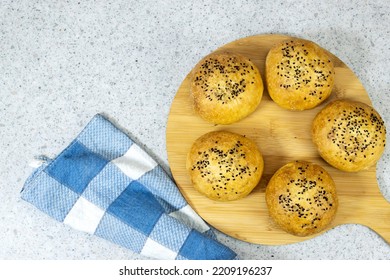 homemade burger buns with sesame on cutting board - Shutterstock ID 2209196237