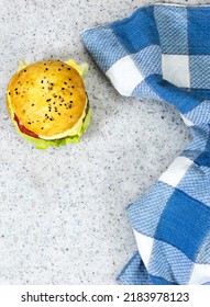 Homemade Burger With Cheese And Meat, Tomato And Salad With Blue Plaid Napkin