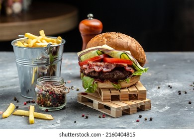 Homemade burger with juicy meat cutlet, vegetables, sauce French fries on rustic gray background. fast food and junk food concept. - Powered by Shutterstock