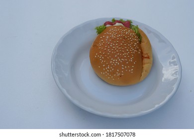 Homemade Burger On White Plate. Fast Food And Junk Food Concept.  High In Calories. It's Not Good To Eat Too Much.