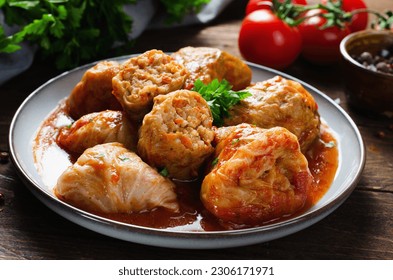 Homemade Cabbage rolls with meat, rice and vegetables. Stuffed cabbage leaves also known as sarma, golubtsy, dolma on Dark Rustic Background