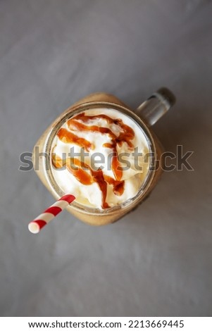  Homemade Caramel Iced Latte with Whipped Cream in a Glass Jar, top view. Flat lay, overhead, from above. 