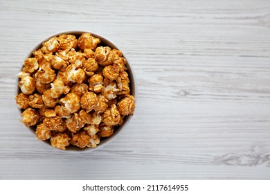 Homemade Caramel Popcorn In A Gray Bowl On A White Wooden Surface, Top View. Flat Lay, Overhead, From Above. Copy Space.