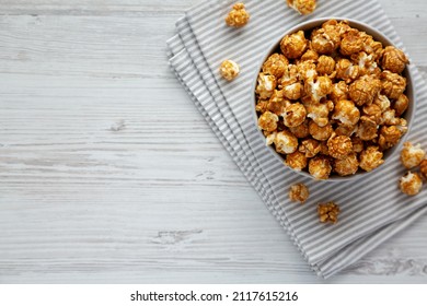 Homemade Caramel Popcorn In A Gray Bowl On A White Wooden Background, Top View. Flat Lay, Overhead, From Above. Space For Text.