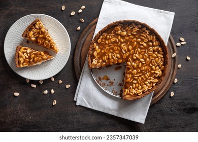 Homemade caramel-peanut cheesecake on a dark background. Morning delicious bakery cake.