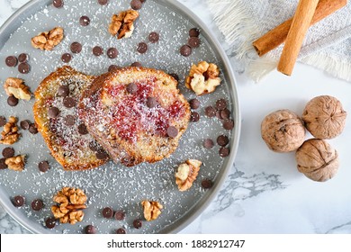 Homemade Carrot Cake With Walnuts And Cinnamon. Overhead Close Up Photo With Whole Walnut Chocolate Chips And Cinnamon Rolls In Grey Dish On White Background. 