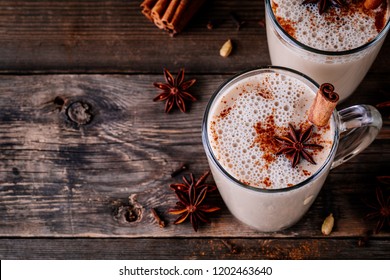 Homemade Chai Tea Latte With Anise And Cinnamon Stick In Glass Mugs On Wooden Rustic Background