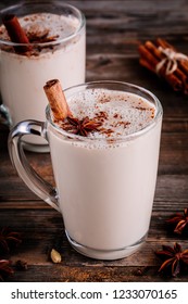 Homemade Chai Tea Latte with anise and cinnamon stick in glass mugs on wooden rustic background