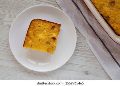 Homemade Cheesy Amish Breakfast Casserole On A White Plate On A White Wooden Background, Top View. Flat Lay, Overhead, From Above. 