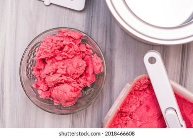 Homemade Cherry Ice Cream In A Plastic Container On The Table Next To An Ice Cream Spoon And An Ice Cream Maker