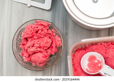 Homemade Cherry Ice Cream In A Plastic Container On The Table Next To An Ice Cream Spoon And An Ice Cream Maker