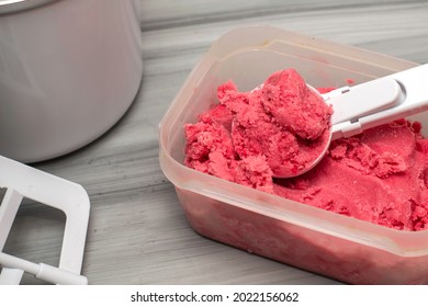 Homemade Cherry Ice Cream In A Plastic Container On The Table With An Ice Cream Spoon And An Ice Cream Maker. High Quality Photo