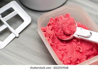 Homemade Cherry Ice Cream In A Plastic Container On The Table With An Ice Cream Spoon And An Ice Cream Maker. High Quality Photo