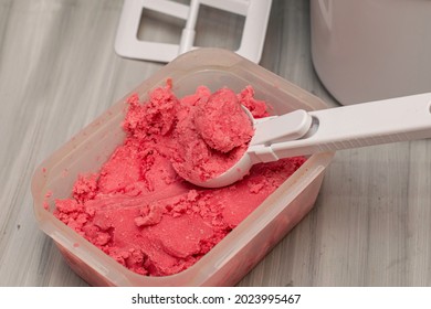 Homemade Cherry Ice Cream In A Plastic Container On The Table With An Ice Cream Spoon And An Ice Cream Maker. High Quality Photo