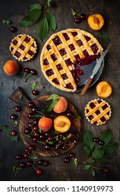 Homemade cherry pie on rustic background with cherries and peaches