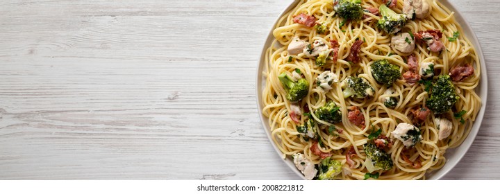 Homemade Chicken Bacon Broccoli Alfredo On A Plate On A White Wooden Background, Top View. Flat Lay, Overhead, From Above. Copy Space.