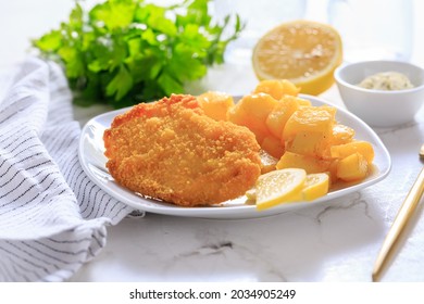 Homemade chicken escalope with baked potatoes, mayonnaise and lemon