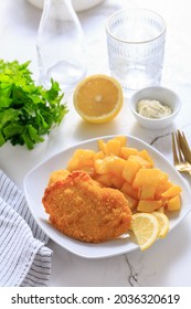 Homemade chicken escalope with baked potatoes, mayonnaise and lemon