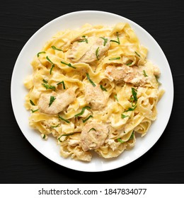 Homemade Chicken Fettuccine Alfredo On A White Plate On A Black Surface, Top View. Flat Lay, Overhead, From Above.