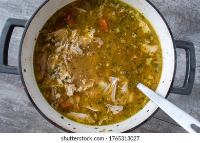Homemade Chicken Noodle Soup With Carrots In Large Pot With Ladle Top View