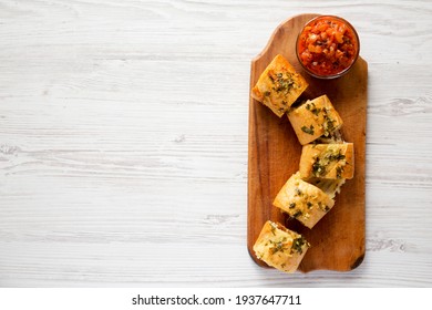 Homemade Chicken Parmesan-Stuffed Garlic Bread On A Rustic Wooden Board On A White Wooden Surface, Top View. Overhead, From Above, Flat Lay. Space For Text.