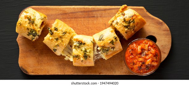 Homemade Chicken Parmesan-Stuffed Garlic Bread On A Rustic Wooden Board On A Black Surface, Top View. Flat Lay, Overhead, From Above. 